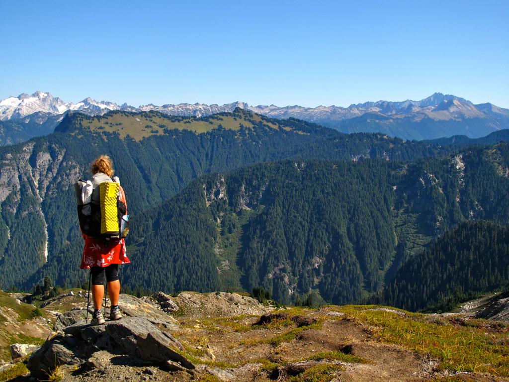 A thru-hiker surveys the view from Fire Creek Pass in Glacier Peak Wilderness. Photo by Stephanie White