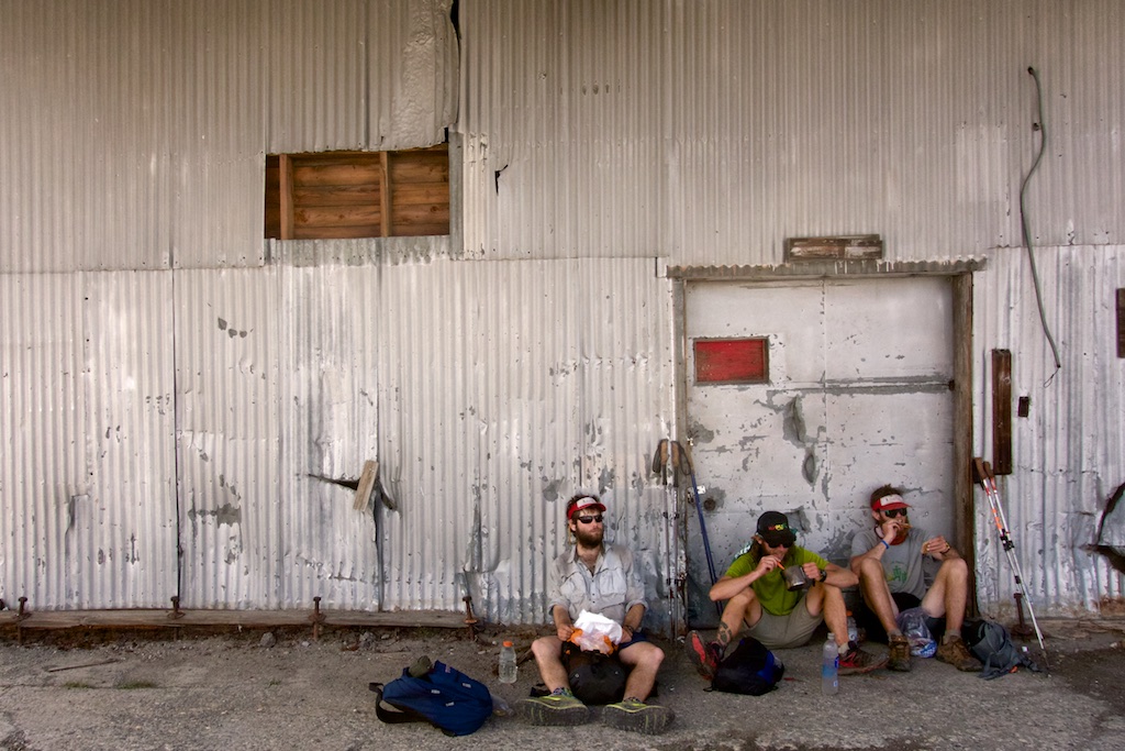 Thru-hikers rest for lunch in the shade of a utility building near Truckee. High Sierra, California