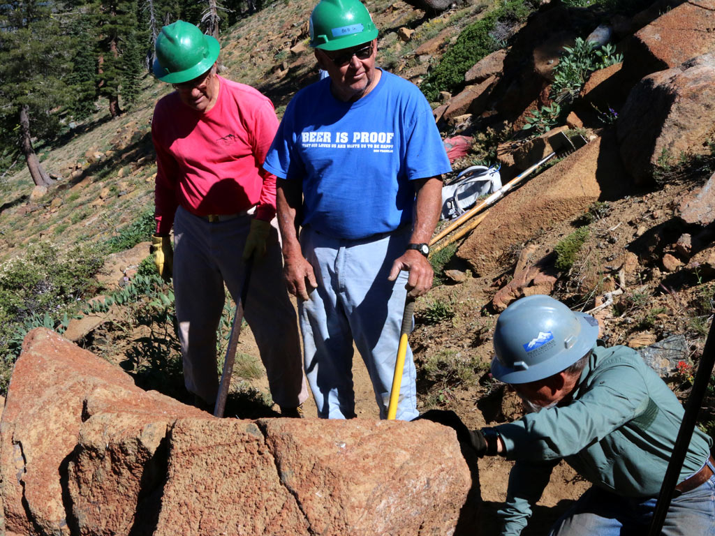 John Lyons takes a break from a team attempt to move a heavy boulder off the trail.  