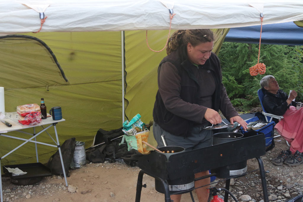 Volunteer cook Sonya Rodgers begins the evening meal under cover.