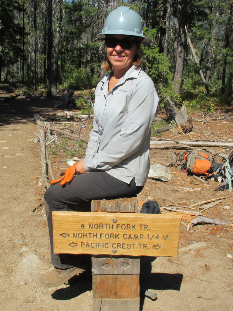 Shannon sitting on a new sign she helped install. Photo by Roberta Cobb