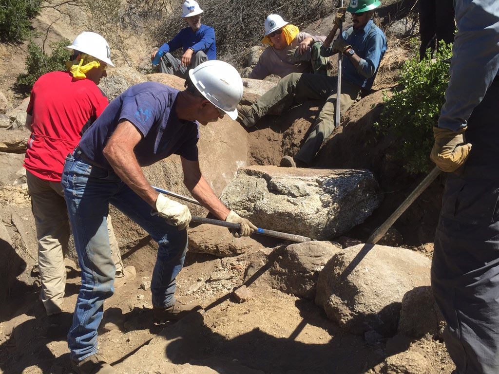 Volunteers are taught to handle and use rock bars while constructing rock-retaining walls – by Connor Swift