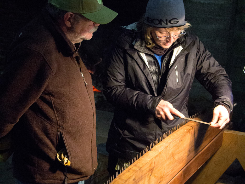 After class, volunteer saw instructor David Roe teaches volunteers how sharpen a traditional crosscut saw – by Joe Smith