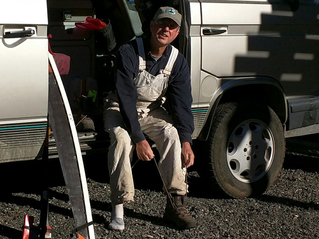 Supremely dedicated volunteer, Kim Owen, ties his newly donated Vasque boots before a day on the trail.