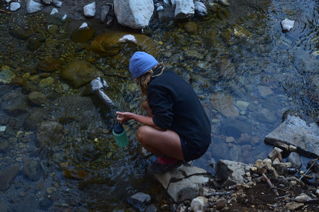 Collecting water from the wilderness. Please protect water quality by not washing your dishes, or yourself, in water sources.