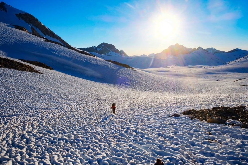 Hiking across an endless field of sun-cupped snow in the Sierra Nevada