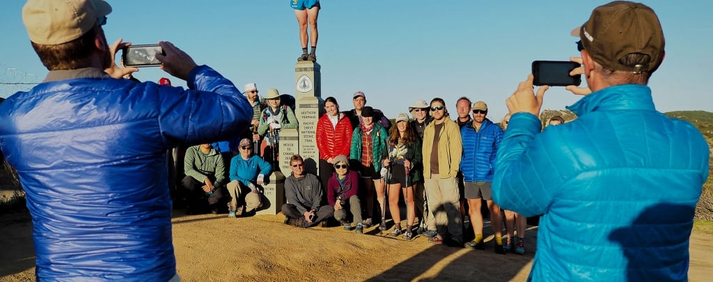 Pacific Crest Trail hikers pose for photos at the Southern Terminus near Campo, CA. Photo by Lon "Halfmile" Cooper