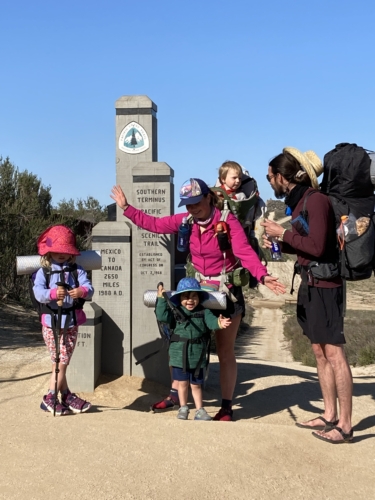 A family poses at the PCT Southern Terminus Monument