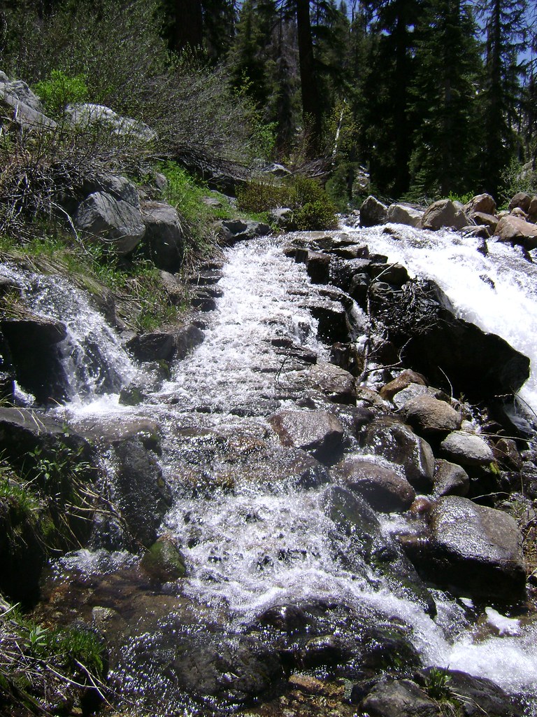Water cascades across the trail